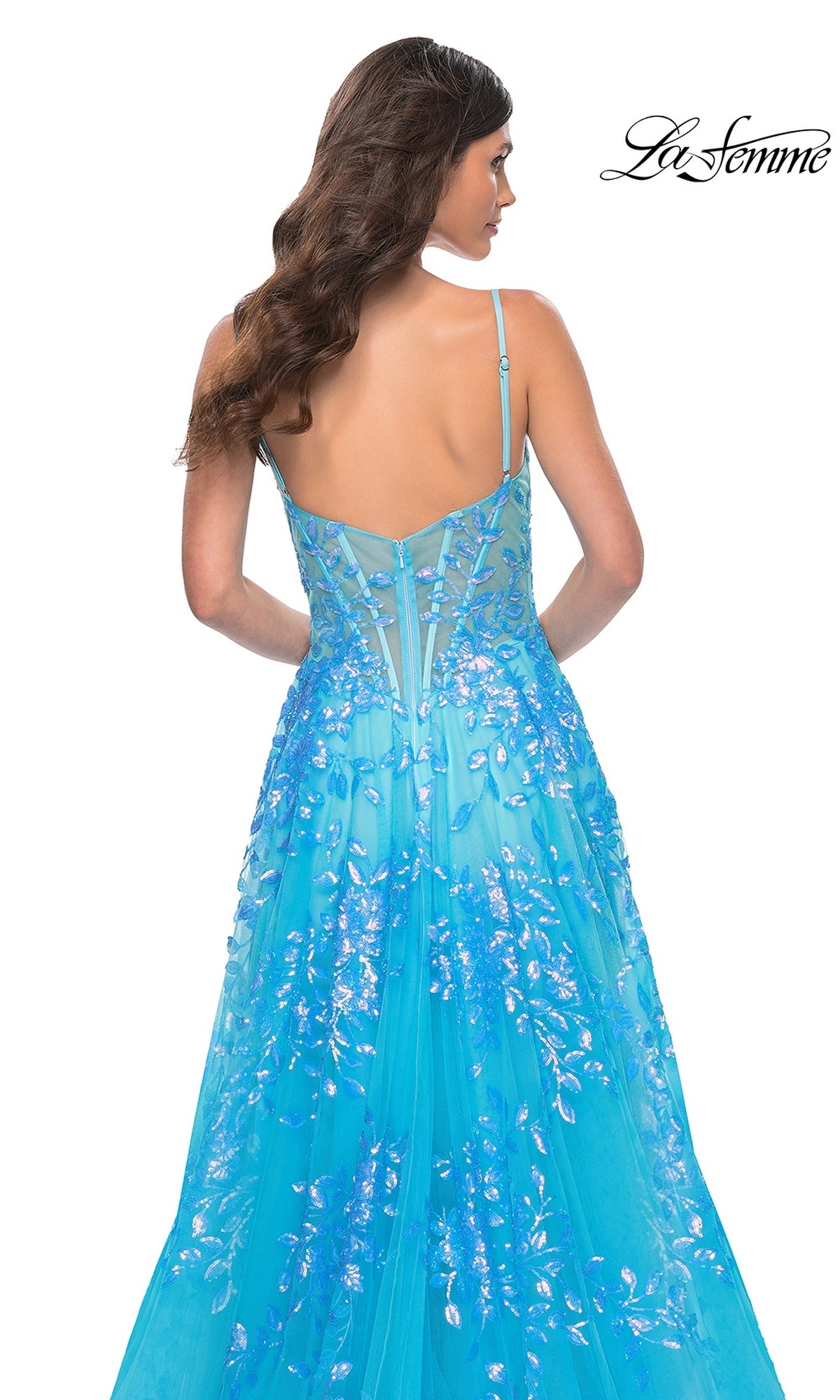 A woman with long brown hair wears the La Femme Sequin-Print Long A-Line Prom Dress 32223, featuring thin straps and a sheer corset back, as she faces away from the camera. The